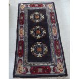 A woollen carpet, decorated with floral and Greek key designs, on a black ground  68" x 36"