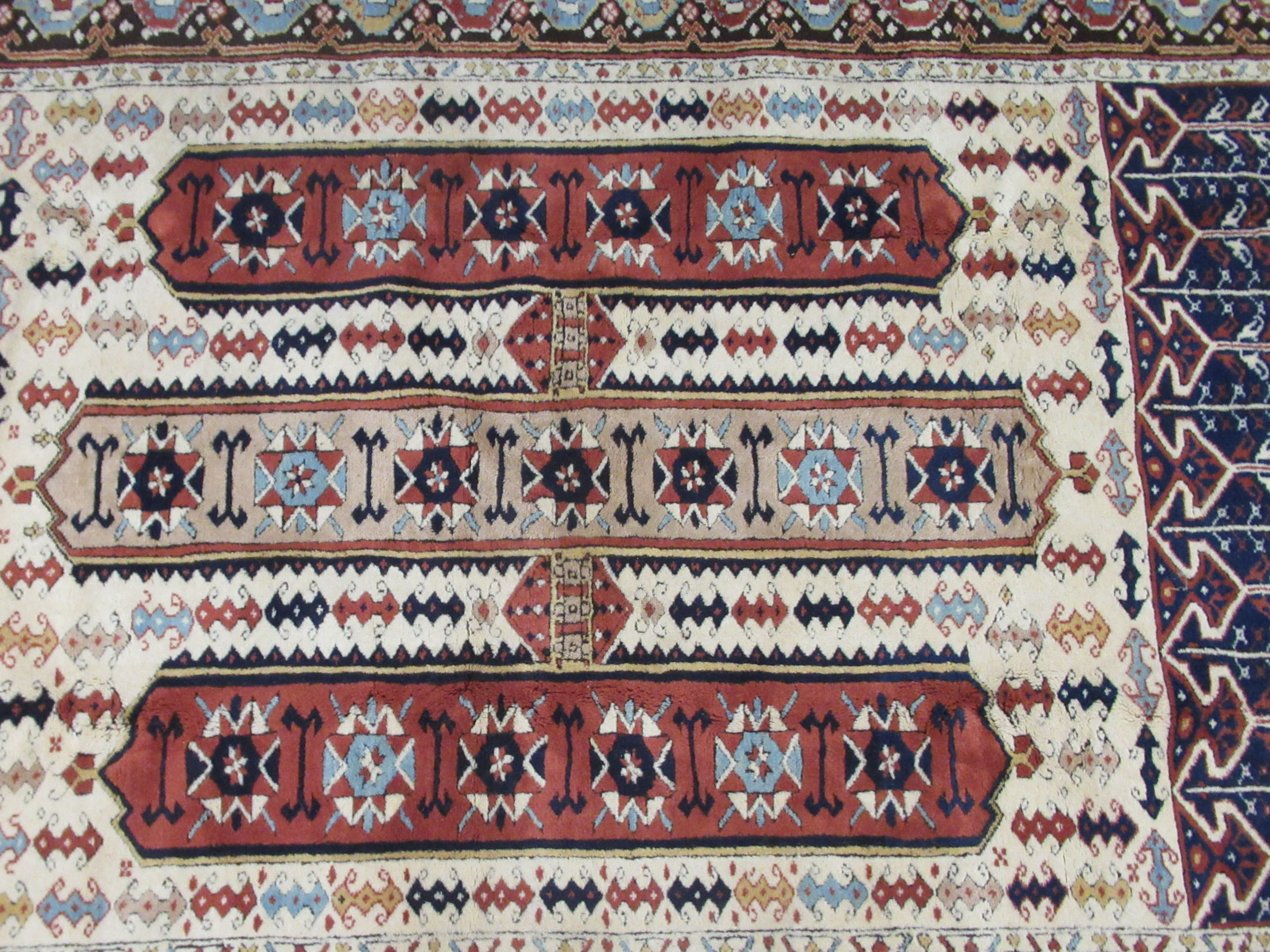 A Caucasian rug, decorated with repeating stylised designs, on a multi-coloured ground  58" x 88" - Image 2 of 5