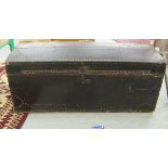 A late Victorian black fabric covered and studded trunk with a domed, hinged lid and paper lined