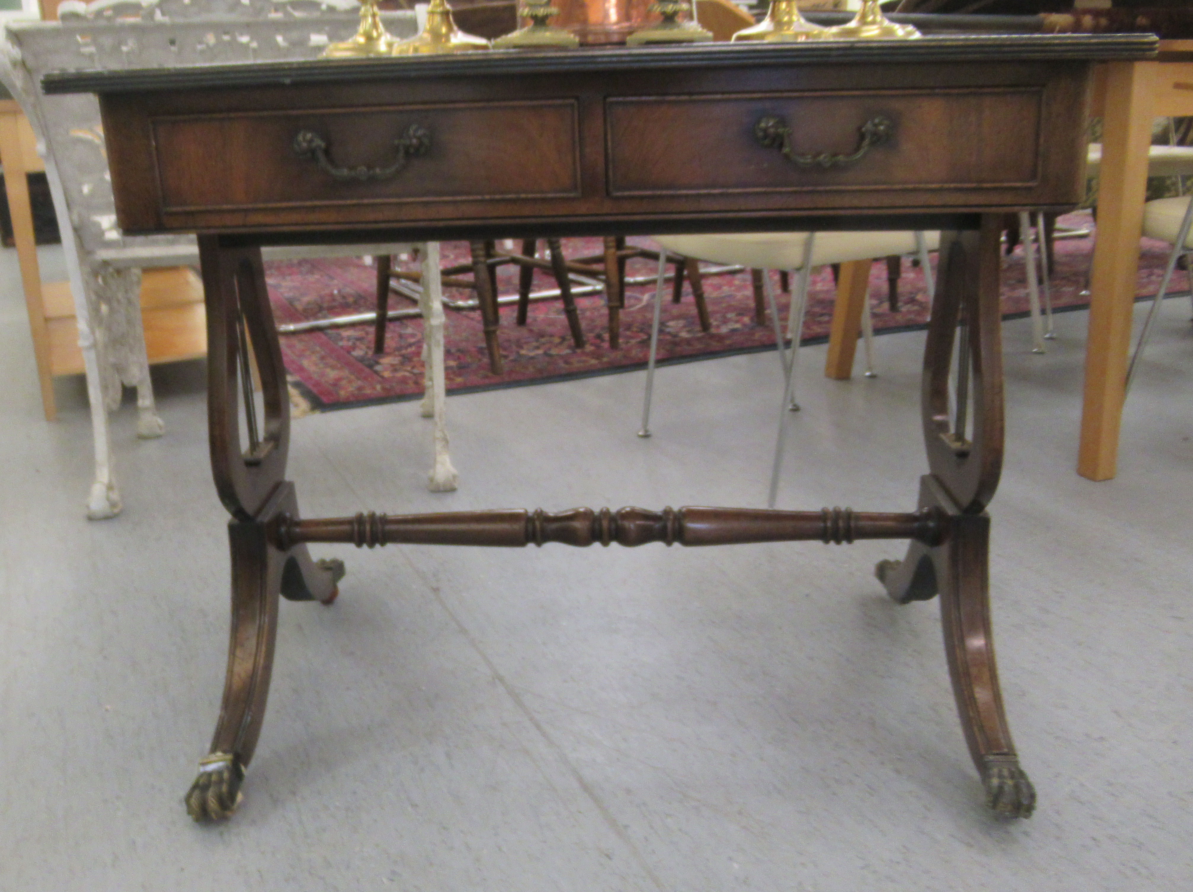 A reproduction of a Georgian writing table, the top set with a tooled green hide scriber, over two