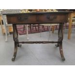 A reproduction of a Georgian writing table, the top set with a tooled green hide scriber, over two