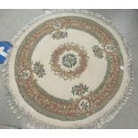 A Chinese washed woollen rug, decorated with floral designs  48"dia