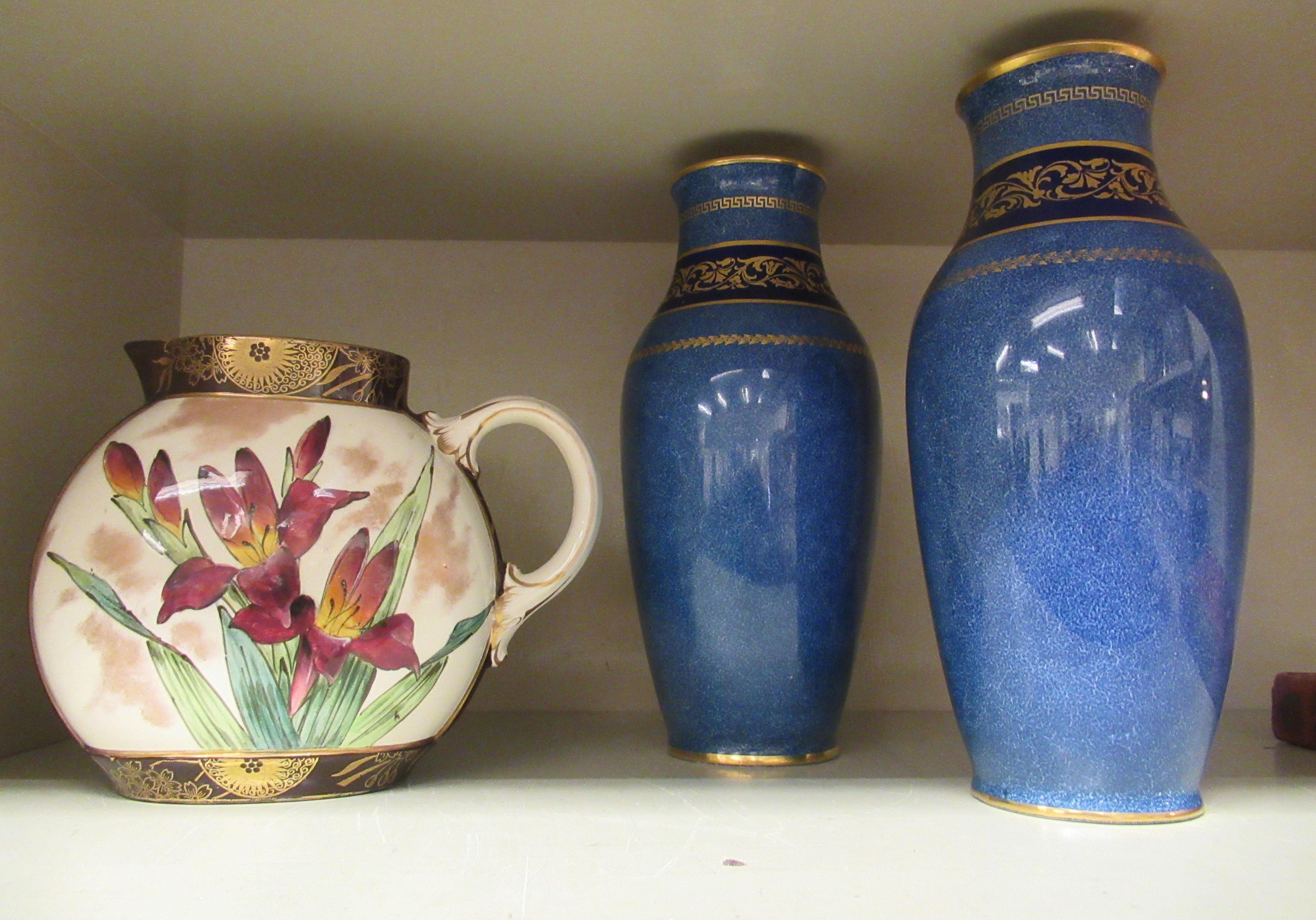 A pair of Royal Doulton sponged blue glazed and gilded baluster shaped vases with flared rims,