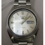 A Seiko 5 stainless steel cased automatic wristwatch, faced by a baton dial with day/date apertures,