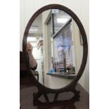 An Edwardian oval dressing table mirror, set in a mahogany frame, on an easel stand  21" x 15.5"