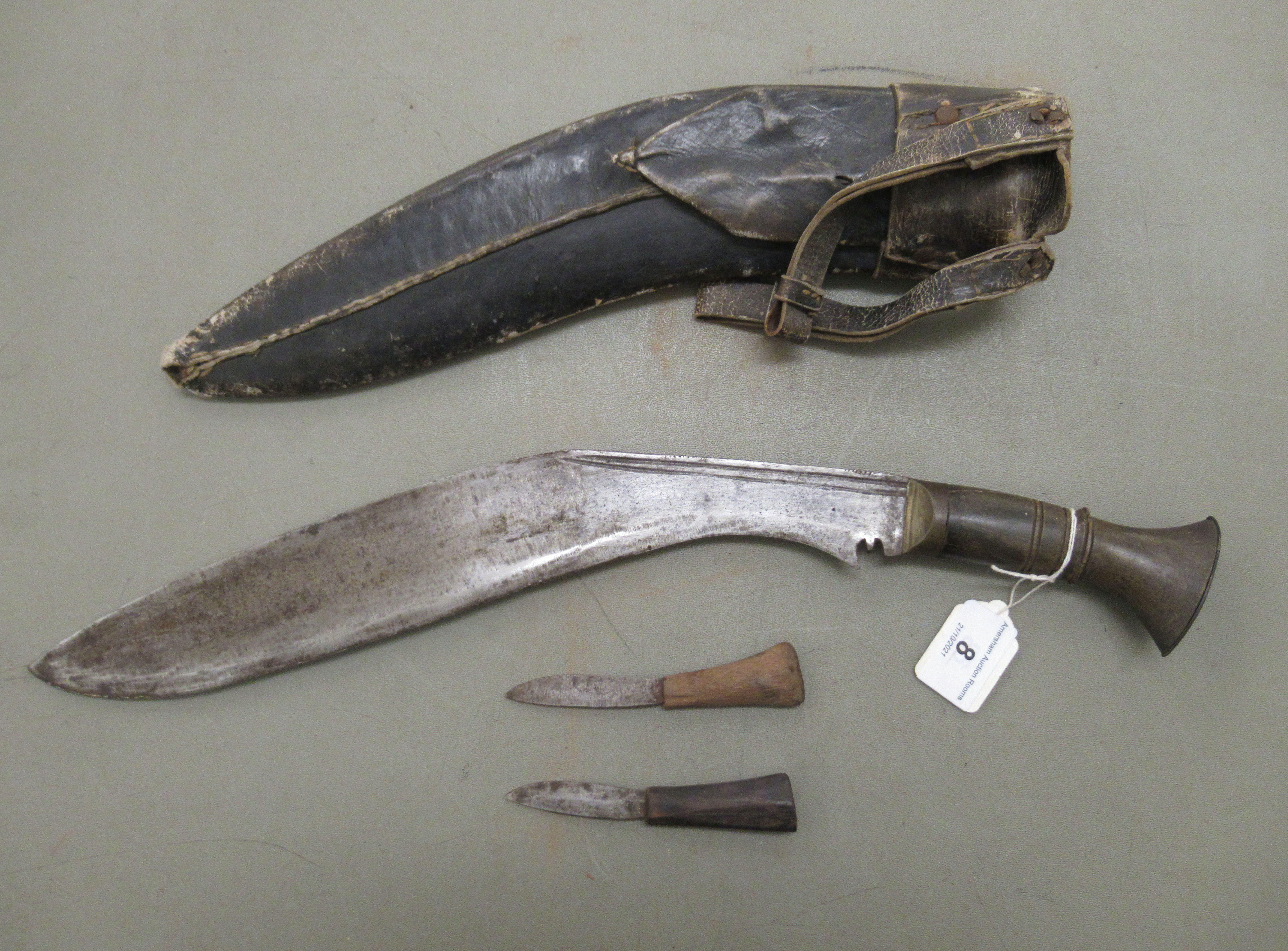 A 20thC Nepalese kukri on a, probably, horn handle  the blade 13"L, in a stitched hide sheath