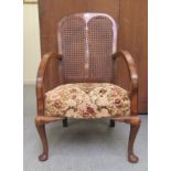 A 1920s/1930s walnut framed chair with a twin panelled, caned back and tapestry upholstered seat,