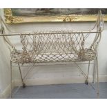 A late Victorian/Edwardian cream painted and wrought iron framed folding bassinet, incorporating a