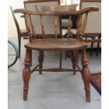 A 1920s beech and elm framed smokers bow with level arms and a solid seat, raised on baluster ring