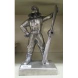 A pewter coloured composition figure of a World War II period aviator, holding a propeller,