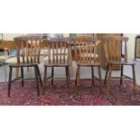 A matched set of four mid 20thC stained beech lath back chairs, the solid seats raised on turned