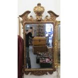 An 18thC design bevelled mirror, set in an ornately moulded gilt frame with a broken arch crest