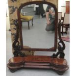 An early Victorian gentleman's mahogany framed toilet mirror, the round arched plate pivoting on