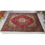 A Persian carpet, decorated with floral and foliate designs, on a red ground  84'' x 138''
