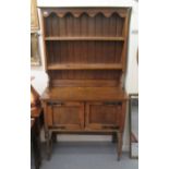 An early 20thC light oak dresser, having a planked back superstructure, over a pair of panelled