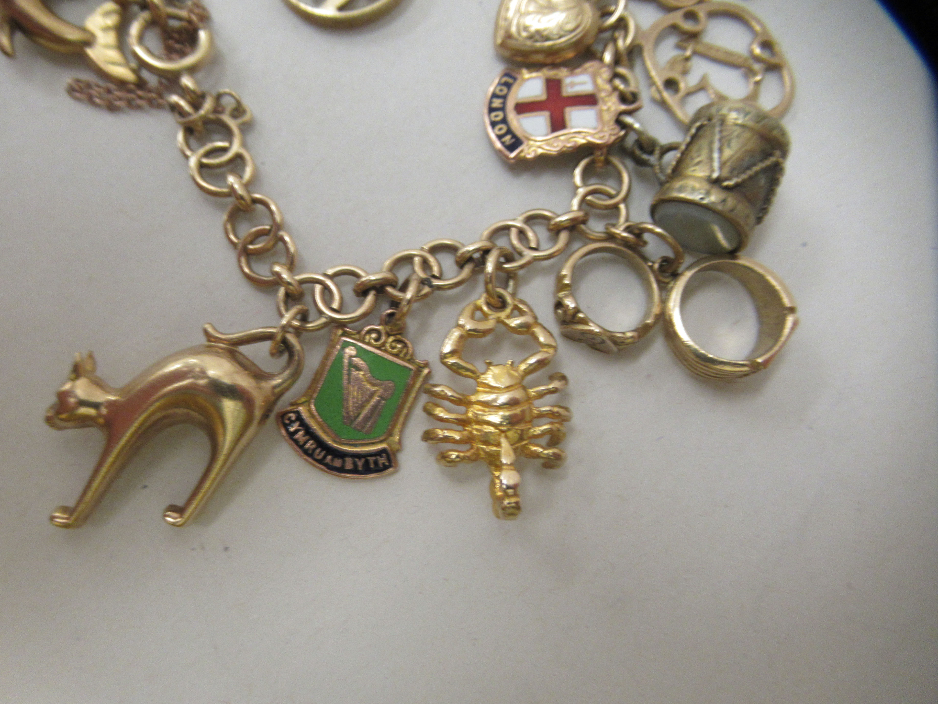 A 9ct gold and yellow metal charm bracelet with various charms - Image 3 of 5