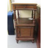 An early 20thC French rosewood bedside cabinet with a mottled grey marble top, a shallow drawer,