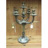 A baronial style lacquered brass candelabrum with four foliate scrolled branches and a central