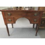 An early 19thC mahogany three drawer kneehole writing table with brass bail handles, on oval