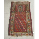 A woollen rug, decorated with geometric designs, on an orange ground  54" x 30"