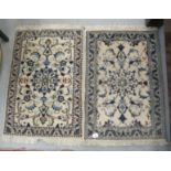 Two similar small Persian rugs, on a cream coloured ground  22" x 34"