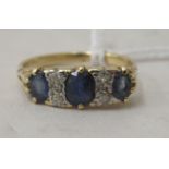 An 18ct gold, three stone sapphire and diamond ring