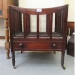 An early Victorian mahogany Canterbury with a base drawer, raised on ring turned legs and castors