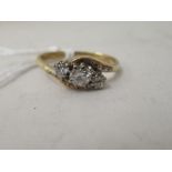 An 18ct gold three stone, crossover set diamond ring