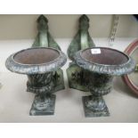 A pair of antique finished patinated cast metal urns  10.5"h each with an attendant painted softwood