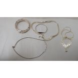 Three dissimilar silver necklaces; and two bangles