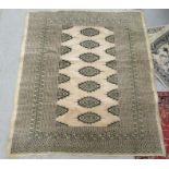 A Bokhara rug, decorated with three columns of eight guls, bordered by stylised designs, on a