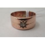 A 9ct rose gold single stone, rubover set diamond, wide band ring