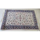 A Tabriz rug, decorated with repeating foliate designs, on a blue and cream coloured ground  88" x