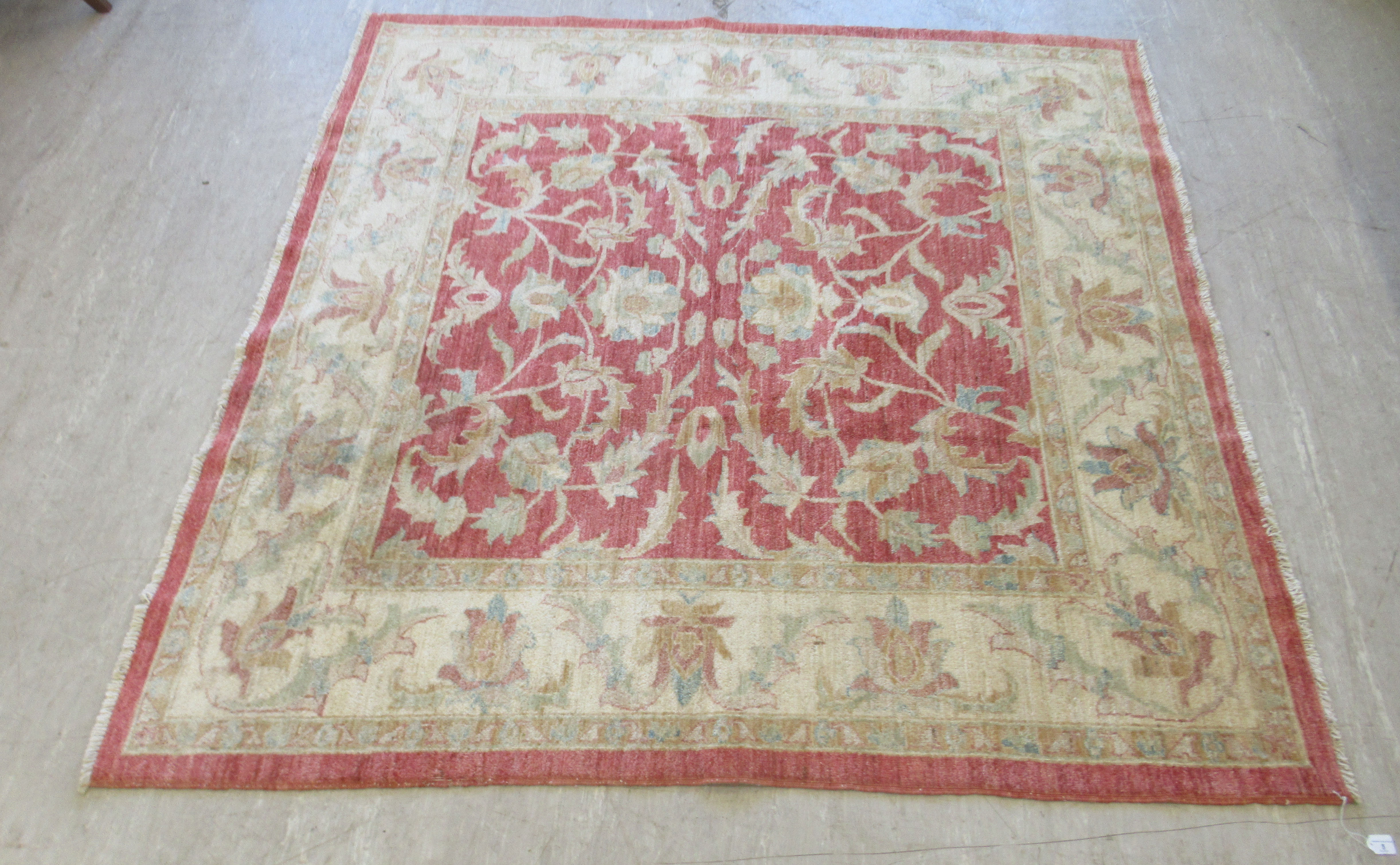 A Ziegler rug, decorated with foliate designs, on a red and cream coloured ground  79" x 78"