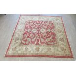 A Ziegler rug, decorated with foliate designs, on a red and cream coloured ground  79" x 78"