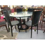 A modern glass topped dining table, raised on a crown design, cast metal base  30"h  47"dia; and a