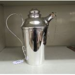A silver plated cocktail jug with a stopper, spout and loop handle