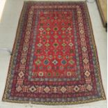 A Persian rug with floral motifs, on a red and blue ground  49" x 78"