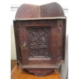 An early 20thC carved and stained oak hanging corner cupboard with a single door  20"h  15"w