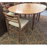 A 1970s teak dining table, the top raised on turned legs  28"h  49"dia with an integral leaf