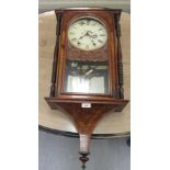 A late 19thC walnut cased wall clock with ring turned pillared flanks and a figure, on a marquetry