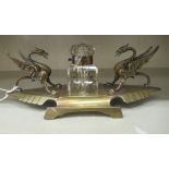 An early/mid 20thC lacquered brass inkstand, fashioned as opposing snarling wyverns with a