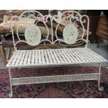 A mid 20thC white painted, wrought iron garden bench with a high back and faux woven seat, raised on