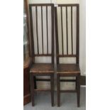 A pair of child's early 20thC stained pine framed, lath back correction chairs, the solid seats