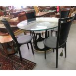 A modern glass topped dining table, raised on a crown design, cast metal base  30"h  47"dia; and a