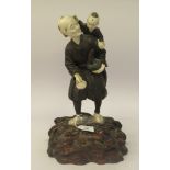 An early 20thC Japanese patinated and painted cold cast bronze and carved ivory group with a boy and