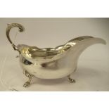 An Edwardian silver sauce boat of oval, bulbous form with a decoratively cut, flared rim and a C-