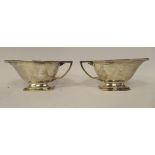 A pair of Art Deco silver sauce boats, each with an angular handle, on a pedestal footrim  Joseph