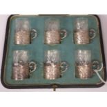 A set of six Edwardian cut crystal cylindrical tot glasses, each set in an embossed and chased