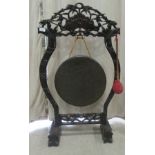 A 19thC Chinese cast bronze gong and Hongmu wood stand with a carved crest rail and uprights, on